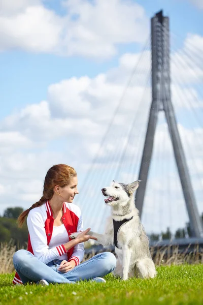 Woman playing with her dog outdoors — Stock Photo, Image