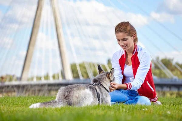 Woman playing with her dog outdoors — Stock Photo, Image