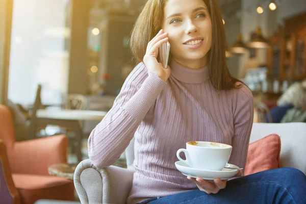 Imagem de jovem sms leitura do sexo feminino no telefone no café — Fotografia de Stock