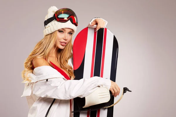 灰色の上に孤立したスノーボードで立っている若い女性 — ストック写真