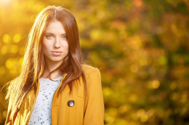 Sonbaharda parkta duran zarif bir kadın. 