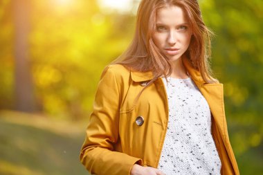 Sonbaharda parkta duran zarif bir kadın. 