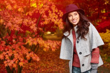 Sonbaharda parkta duran zarif bir kadın.