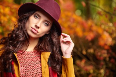 Sonbaharda parkta duran zarif bir kadın. 