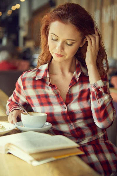 那个女孩在咖啡馆喝咖啡看书 — 图库照片