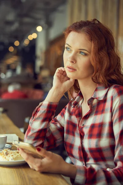 Fata bea cafea într-o cafenea și citește o carte. — Fotografie, imagine de stoc