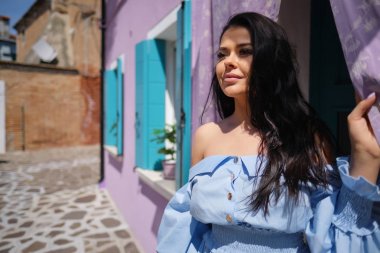 Burano adasında renkli evler arasında poz turist kadın, Venedik. İtalya'da turizm konsepti 