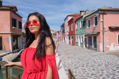 Burano adasında renkli evler arasında poz turist kadın, Venedik. İtalya'da turizm konsepti 