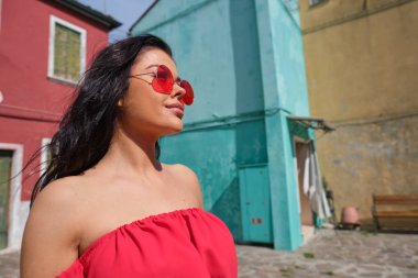 Burano adasında renkli evler arasında poz turist kadın, Venedik. İtalya'da turizm konsepti 