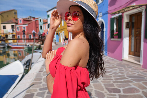 туристическая женщина позирует среди красочных домов на острове Бурано, Венеция. Концепция туризма в Италии
 