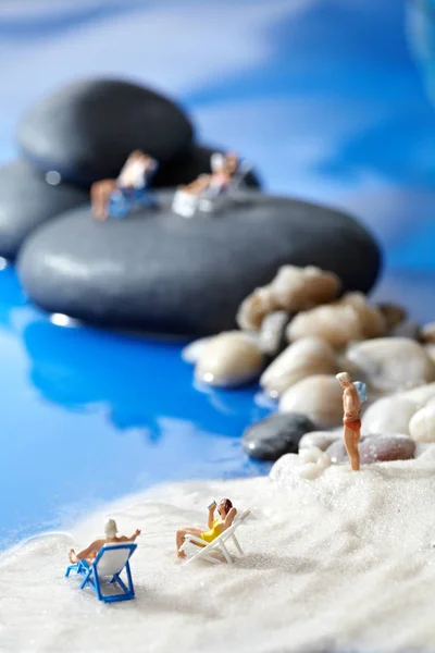 Visão traseira de um casal em miniatura em uma cadeira de praia relaxante no — Fotografia de Stock