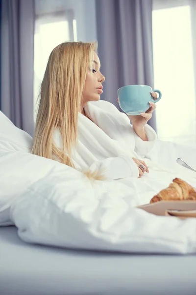 Joven hermosa mujer desayunando en la cama. — Foto de Stock