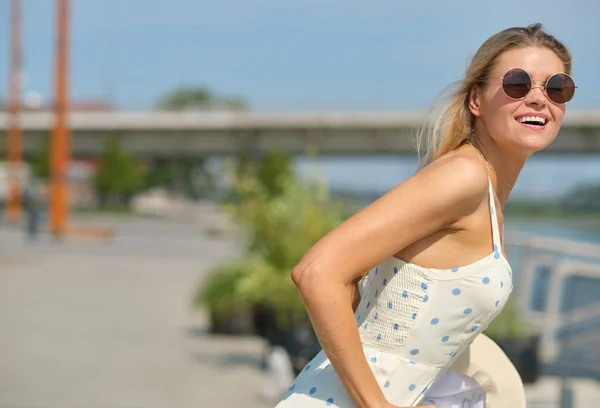 Vacker sommar kvinna i vit klänning. City River bakgrund. — Stockfoto