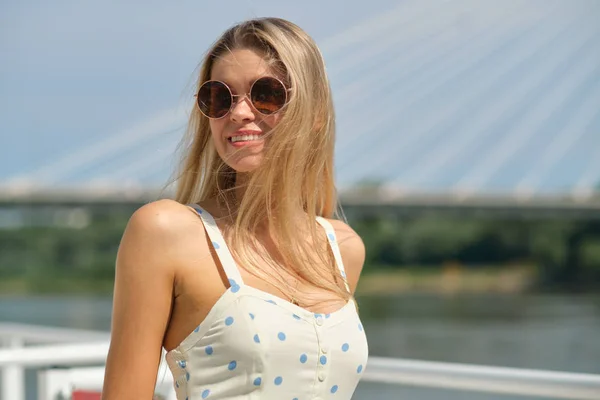 Mooie zomer vrouw in witte jurk. City River background. — Stockfoto