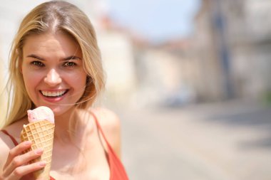 bir yaz elbise güneşli bir kız dondurma yiyor ve t etrafında yürüyor