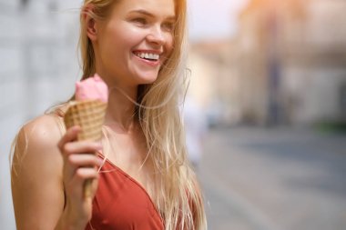 bir yaz elbise güneşli bir kız dondurma yiyor ve t etrafında yürüyor