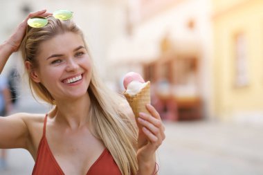 bir yaz elbise güneşli bir kız dondurma yiyor ve t etrafında yürüyor