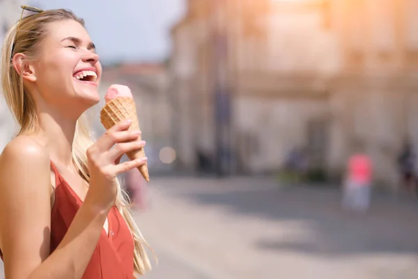 Slunné děvče v letních šatech sní zmrzlinu a chodí kolem t — Stock fotografie