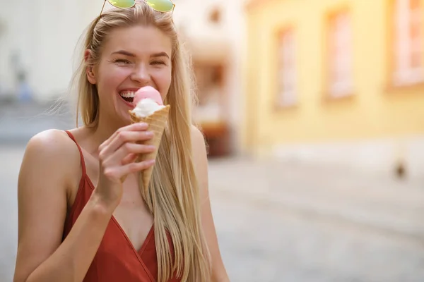 Una chica soleada en un vestido de verano come helado y camina por t —  Fotos de Stock