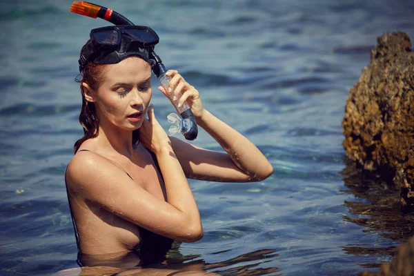 Sexy woman with fins and crossbow is preparing to hunt for fish — Stock Photo, Image