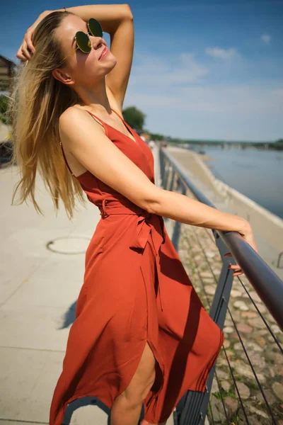 Splendida bella donna in abito rosso lungo e cappello a piedi. Po — Foto Stock