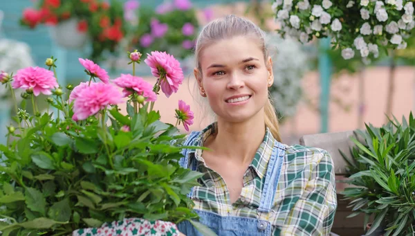 Jonge vrouw tuinieren in de kas. Ze selecteert bloemen. — Stockfoto