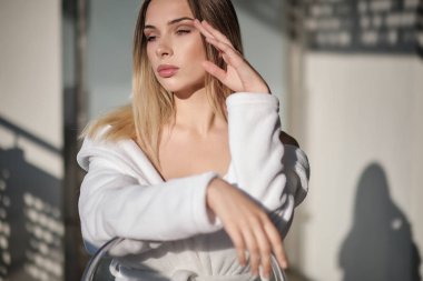 beyaz bornoz kız balkonda oturur