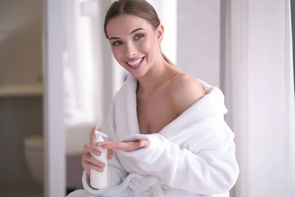 Portrait of pretty young woman applying body cream on skin — Stock Photo, Image