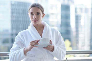 Balkonda duran bornozlu esmer kadınların portresi d