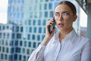 Th arka planda akıllı telefon ile güzel iş kadını