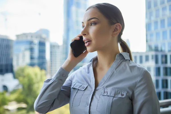 Mulher de negócios bonita com smartphone no fundo do th — Fotografia de Stock