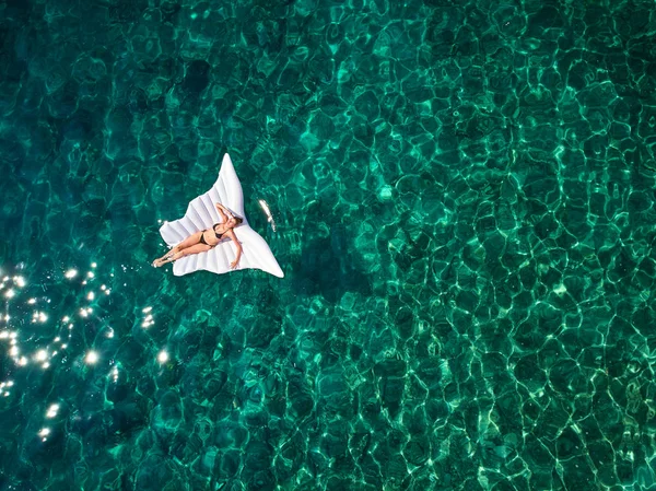 Blick von oben auf eine schöne Frau in einem weißen Bikini, die schwimmt — Stockfoto