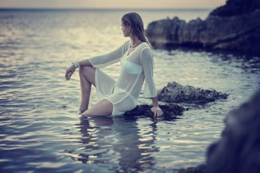 Genç ve güzel bir kadın suyun içinde duruyor..