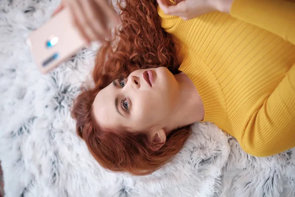 Lächelnd attraktive junge Frau mit schönen langen roten Haaren lyin — Stockfoto