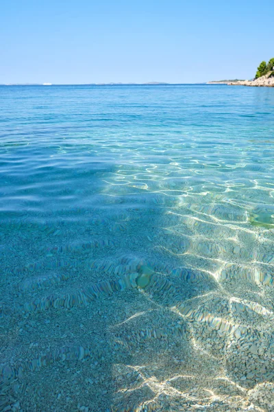 Křišťálově čistá modrá zelená Jaderské moře a skalnatá pláž na i — Stock fotografie