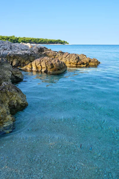 Cristalino azul claro mar Adriático verde e uma praia rochosa no i — Fotografia de Stock