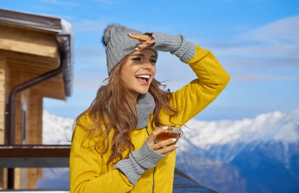 Mujer bebiendo té caliente en la terraza rústica de madera en la montaña — Foto de Stock