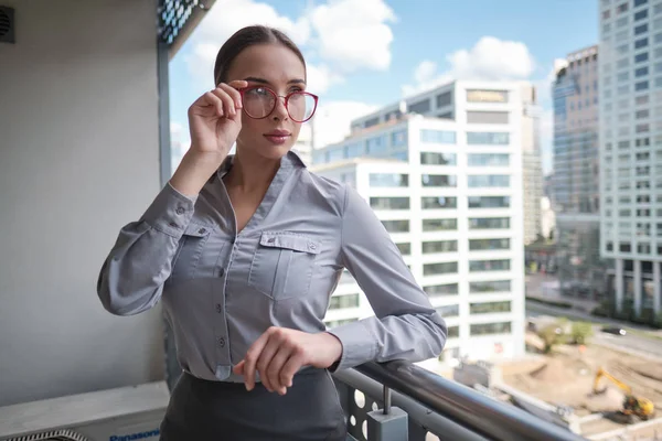 Modern ofisin arka planında güzel bir iş kadını — Stok fotoğraf