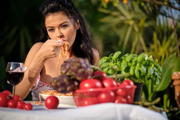 Schöne Frau im Sommerkleid isst italienische Spaghetti mit — Stockfoto