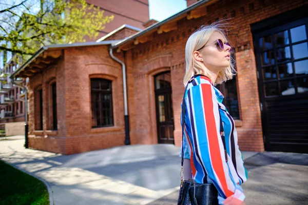 Девушка на прогулке по городу в красочной рубашке — стоковое фото
