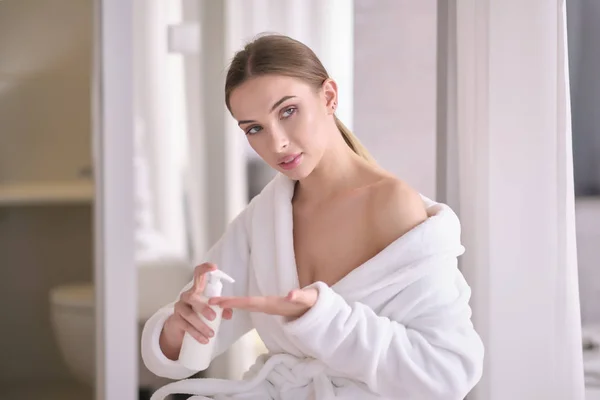 Jonge vrouw met een vlekkeloze huid, het aanbrengen van hydraterende crème op h — Stockfoto