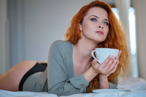 Mooi meisje op haar slaapkamer het drinken van thee in de ochtend. — Stockfoto