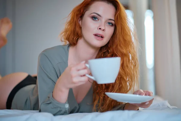 Όμορφο κορίτσι στο υπνοδωμάτιό της, πίνοντας τσάι το πρωί. — Φωτογραφία Αρχείου