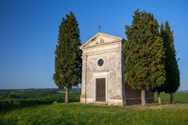 A vertical shot of the famous historic Chapel Vitaleta in the middle of a field in Italy