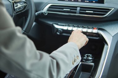 Modern bir elektrikli arabanın klimasını şoför kontrol ediyor.