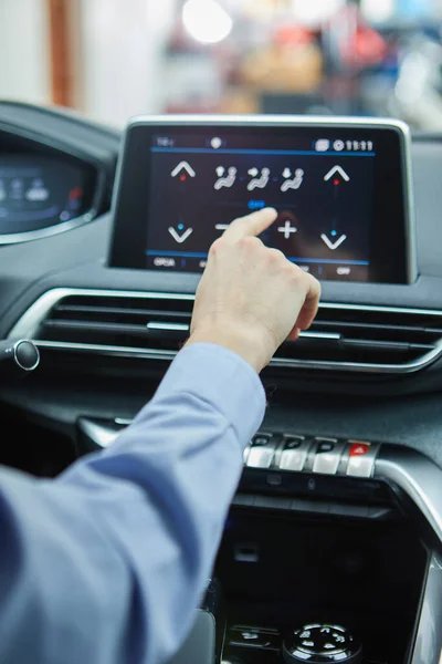 the driver controls the air conditioning in a modern electric car