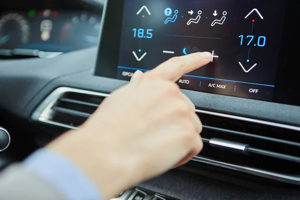 the driver controls the air conditioning in a modern electric car