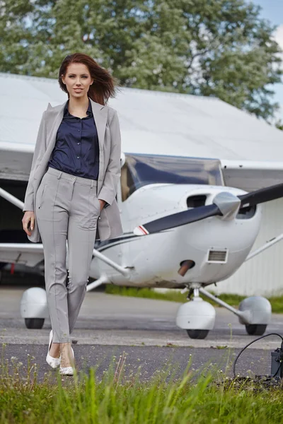 小さな民間航空機の近くに屋外に立つ美しい若い実業家 — ストック写真