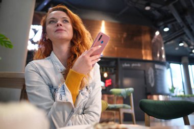 Genç, çekici bir kadın cep telefonuyla arıyor. Boş zamanlarında kafede tek başına oturuyor. Güzel gülüşlü çekici bir kadın kafede dinlenirken cep telefonuyla konuşuyor.