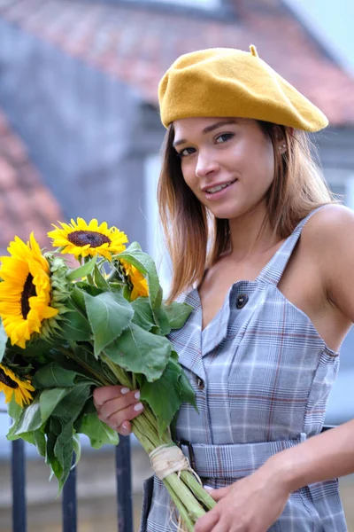 在城市里 年轻的时尚女性 戴着一束向日葵 — 图库照片